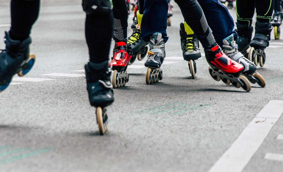 Grupo patinando en línea por una calle urbana; fotografía ilustrativa